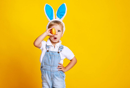 有趣的，快乐的孩子，带着复活节彩蛋和兔子耳朵的黄色背景