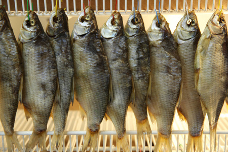 挂在市场上钩子上的干鱼照片