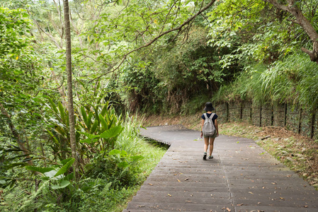 一位亚洲妇女带着背包在户外徒步旅行