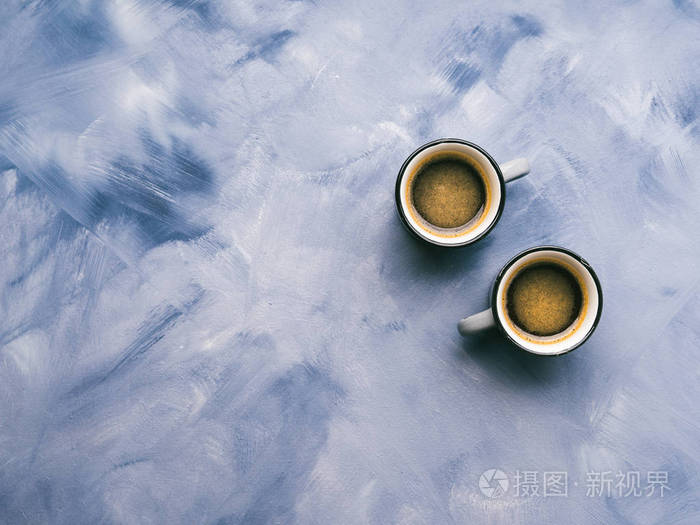 两个咖啡杯在天空蓝色被绘的背景