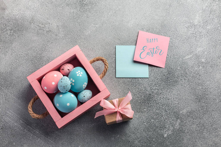 五颜六色的复活节鸡蛋在盒子里，礼物在桌子上。顶部视图，复制空间
