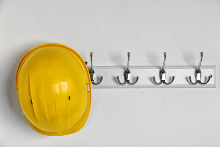 挂在白色墙上的安全帽. 安全设备照片