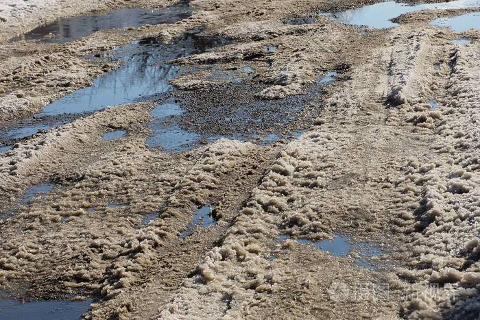 道路一侧灰色雪泥和水坑的背景