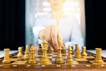 女商人的手在比赛中移动象棋人物的成功发挥。 战略管理或领导概念