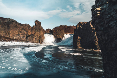 著名的 hjalparfoss 双瀑布在冰岛南部与天空和云。在冰岛徒步。旅游和景观摄影概念