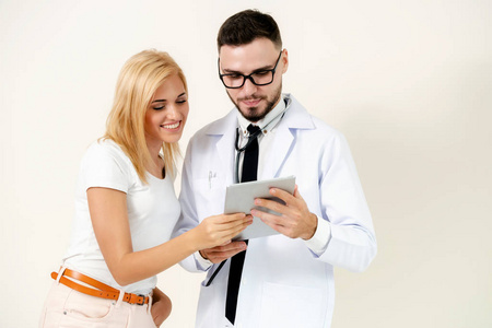 男医生和女病人看平板电脑进行健康数据记录。 医疗保健和医疗服务。