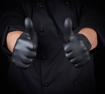 s hand in black latex gloves and black uniform shows a gesture o