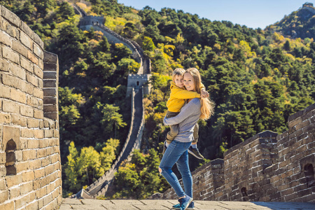 快乐愉快愉快快乐的游客妈妈和儿子在中国长城有乐趣的旅行微笑和跳舞在亚洲度假旅行。中国的目的地。在中国与儿童一起旅行