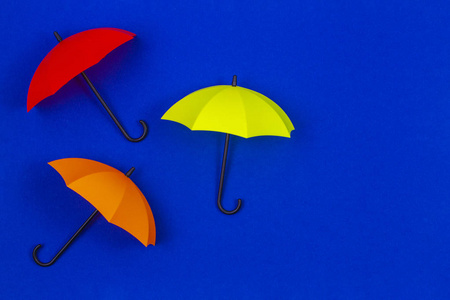 蓝色背景上的彩色小雨伞