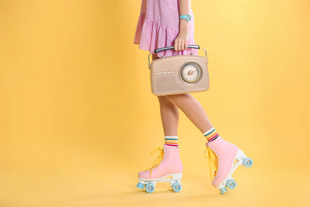 年轻女子带着溜冰鞋和复古收音机的彩色背景特写。 文本空间