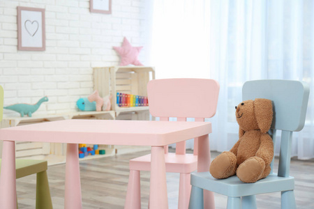 舒适的儿童房内部有桌椅和玩具兔子