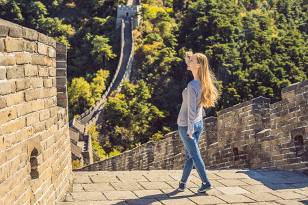 快乐快乐快乐快乐的旅游女人在中国长城有乐趣的旅行微笑和跳舞在亚洲度假旅行。女孩参观和观光中国目的地