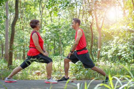 快乐的亚洲母亲和儿子适合跑步者在公园跑步前伸展身体，老年人护理锻炼体育活动概念