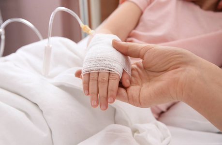 s hand with intravenous drip in hospital, closeup