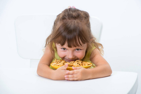 可爱，快乐，微笑，情感和积极的女孩，3岁，穿黄色T恤，在桌子上吃麦片片，孤立在白色背景上。