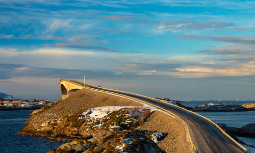 大西洋公路在冬季晴天。 著名的海上高桥叫斯托西桑布鲁阿，在地平线上有美丽的雪山。
