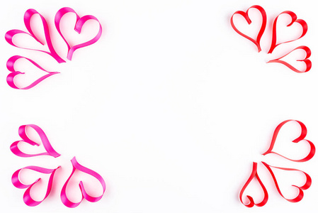 心由粉红色和红色缎带在白色背景上与剪裁路径和复制空间在中间视图从顶部。 情人节的概念。