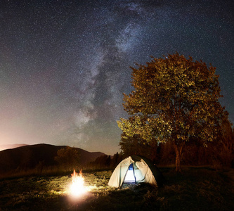 闪耀的帐篷和篝火在惊人的夜空下充满了星星和银河