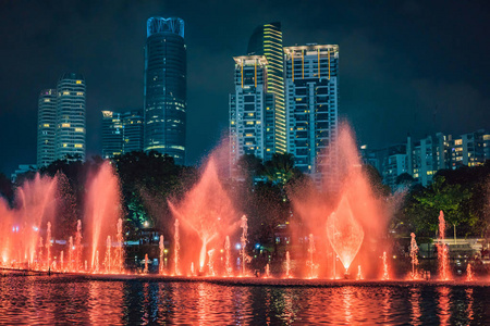 晚上, 湖上的五颜六色的喷泉, 靠近双子塔, 背景是城市。吉隆坡, 马来西亚