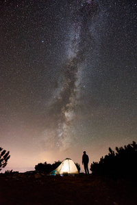 夜间在山顶露营的男徒步旅行者剪影