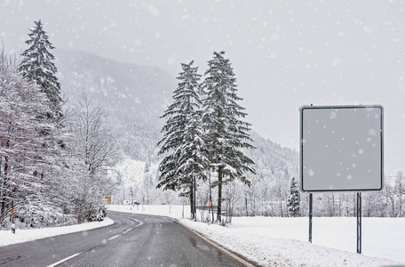 积雪覆盖的冬季森林有助于降雪。 路上的盘子给你发短信。