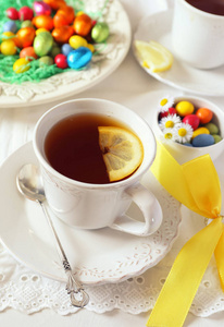 复活节心情一杯柠檬茶饮料，背景上有五颜六色的糖果。 调色图像