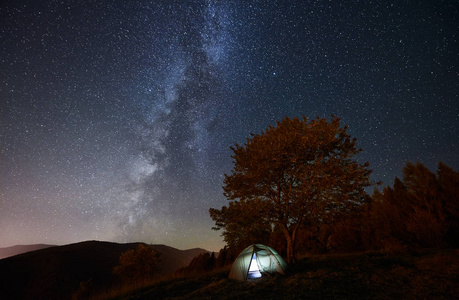 闪耀的帐篷和篝火在惊人的夜空下充满了星星和银河