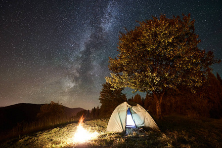 闪耀的帐篷和篝火在惊人的夜空下充满了星星和银河