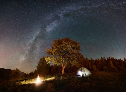 闪耀的帐篷和篝火在惊人的夜空下充满了星星和银河