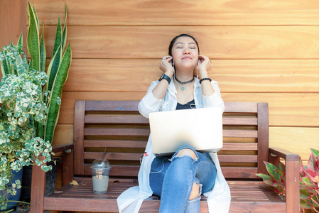 生活方式女性自由职业者喜欢听音乐和玩笔记本电脑户外工作空间在咖啡