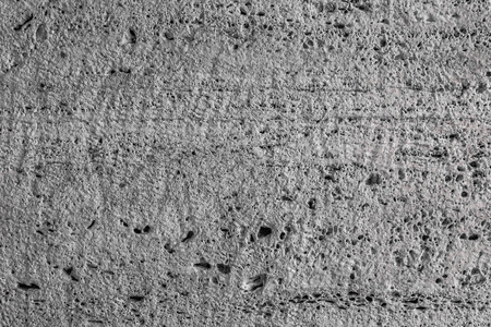 纹理不均匀的石材表面。 灰色石灰石。 表面是通过锯块形成的。 背景图像。 建筑材料。