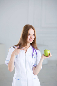 女医生是一位营养学家，绿苹果看着相机。
