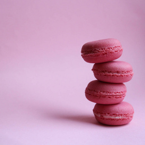 浅粉色背景下的四个粉红色马卡龙,最低食品概念照片