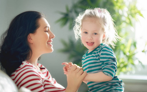 s day Mom and her daughter child girl are playing, smiling and 