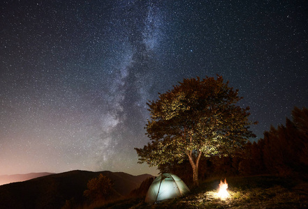 闪耀的帐篷和篝火在惊人的夜空下充满了星星和银河