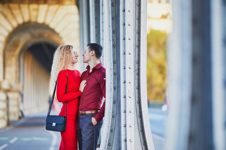 浪漫的情侣在巴黎的伯哈金桥上漫步