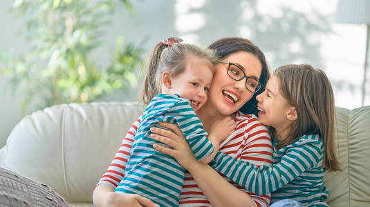 s day Mom and her daughters children girls are playing, smiling