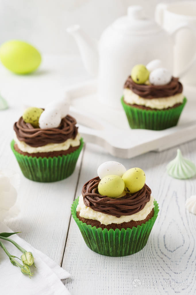 复活节巧克力纸杯蛋糕装饰巢和糖果蛋作为甜点节日糕点的概念