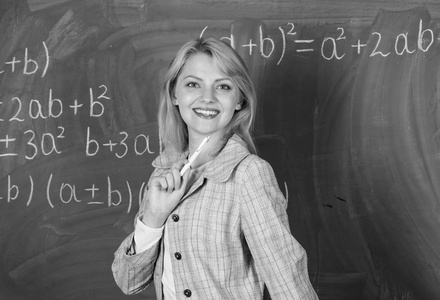 妇女微笑的教育家教室黑板背景。教师的工作条件。她喜欢她的工作。回到学校的概念。未来教师必须考虑的工作条件