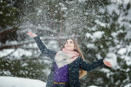 漂亮的女孩在一个令人惊奇的冬天玩雪。