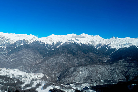 在滑雪场欣赏美丽的雪山和蓝天清澈的景色