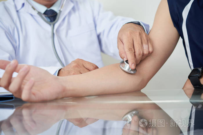 年轻男性病人听诊器检查脉搏的医生照片-正版商用图片18qj9h-摄图新