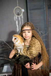 风鹰剑可爱的女孩留着长发,怀里抱着一只白猫头鹰,她的风格是波霍照片