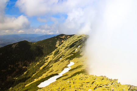 一片巨大的云包裹着绿色的喀山脉