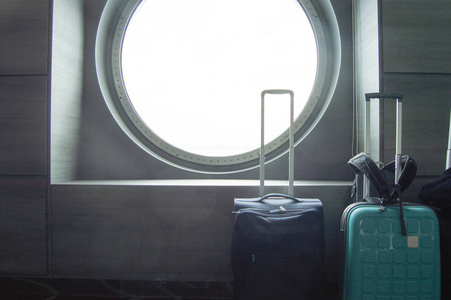 两个手提箱在船的圆形舷窗前旅行，休闲或商务旅行的概念。