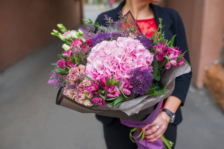 女人手里拿着一束漂亮的花。 3月8日妇女日。 绣球花属康乃馨。 特写照片