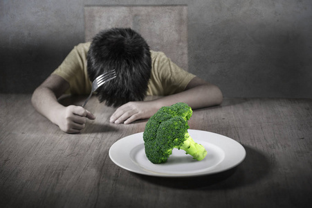 8岁的孩子对拒绝吃健康的绿色西兰花感到厌恶和不快，对健康新鲜食物的儿童营养教育感到不安，而小男孩讨厌吃素食