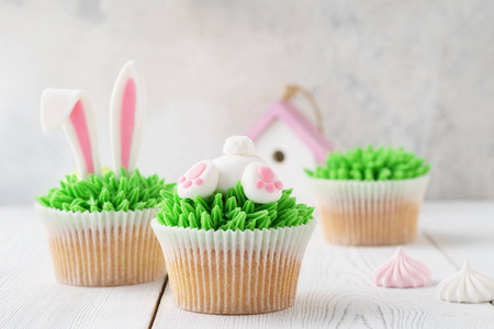 复活节纸杯蛋糕装饰草兔屁股和耳朵作为甜点。