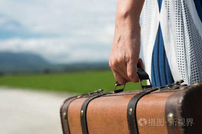 在农村的路上女人提着一个手提箱