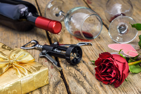 s Day concept. Gift box, red rose, corkscrew, wine bottle and gl